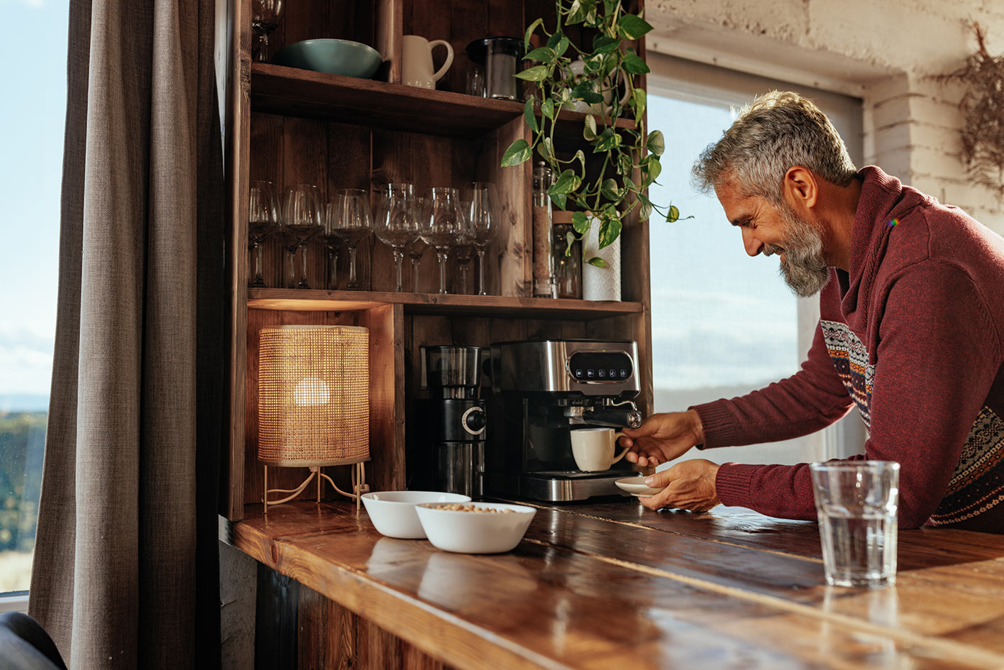 Mann bereitet Espresso an der eigenen Holzbar im selbst gestalteten Rückzugsraum zu